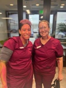 Picture of two students in scrubs with paint of their face